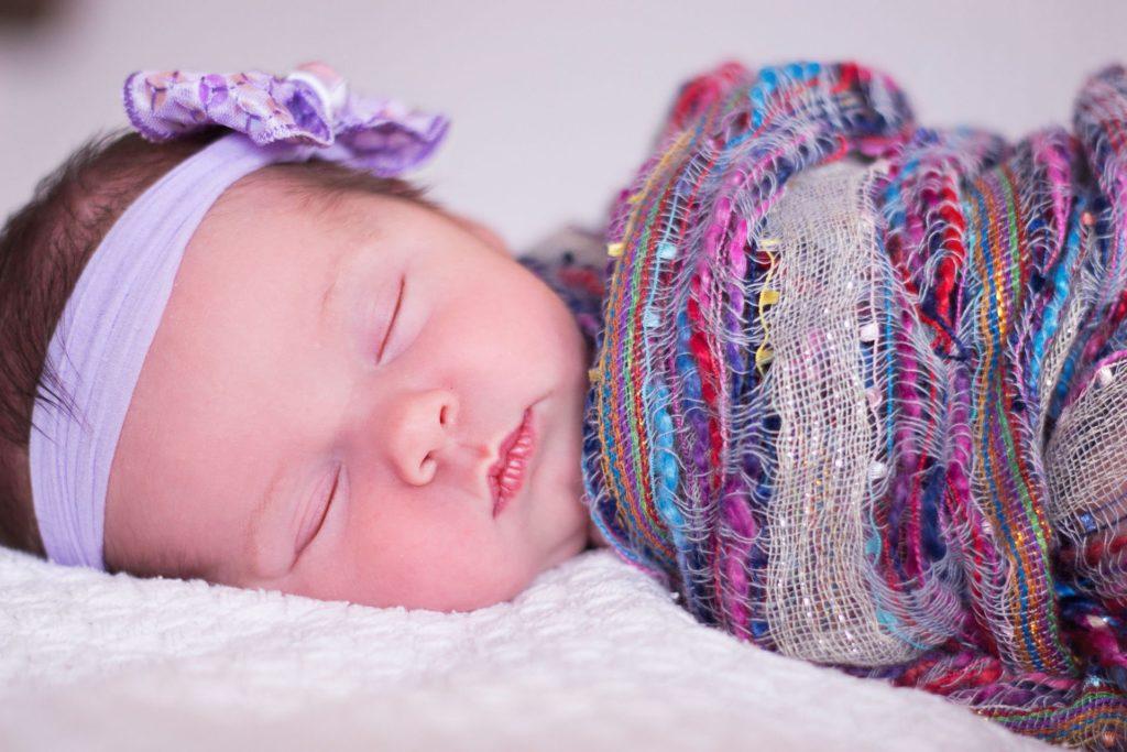 Baby girl sleeping while parents ponder the best girl middle names