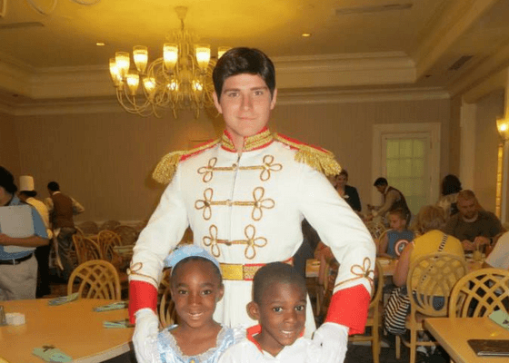 Disney prince charming in character with two children