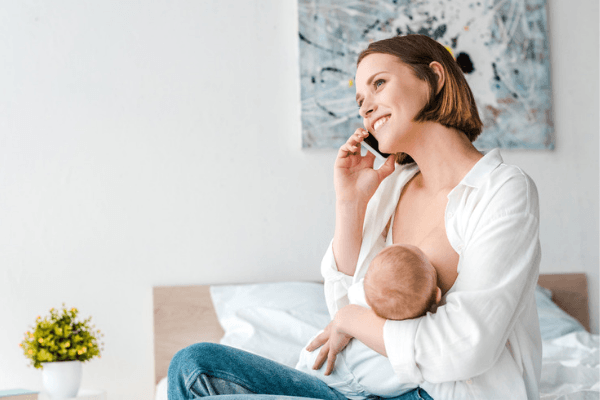 woman on phone while breastfeeding